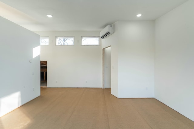 carpeted spare room featuring a wall unit AC