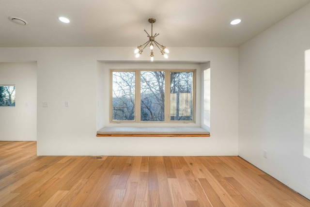 unfurnished dining area with light hardwood / wood-style flooring and an inviting chandelier