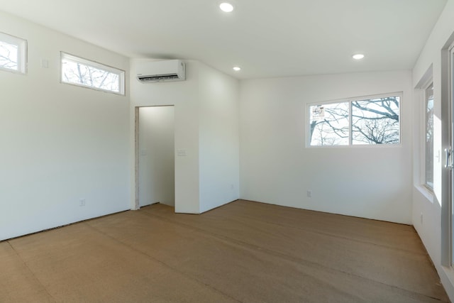 spare room with a healthy amount of sunlight and an AC wall unit