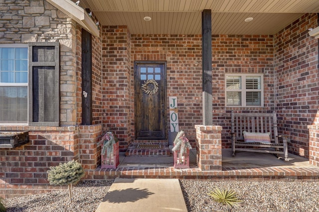 view of exterior entry featuring covered porch