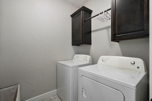 clothes washing area with cabinets and independent washer and dryer