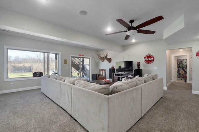 carpeted living room with ceiling fan and a healthy amount of sunlight