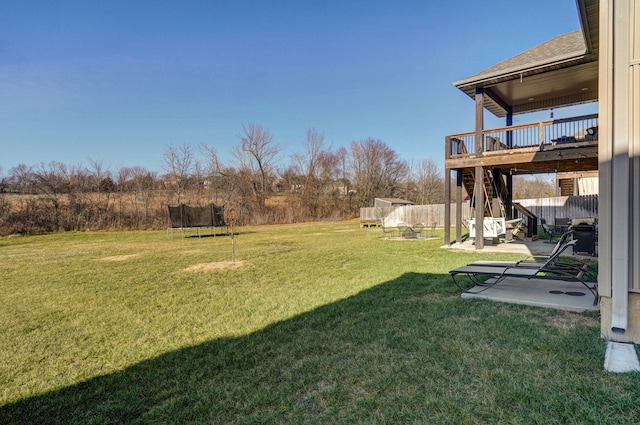 view of yard with a patio area, a wooden deck, and a trampoline