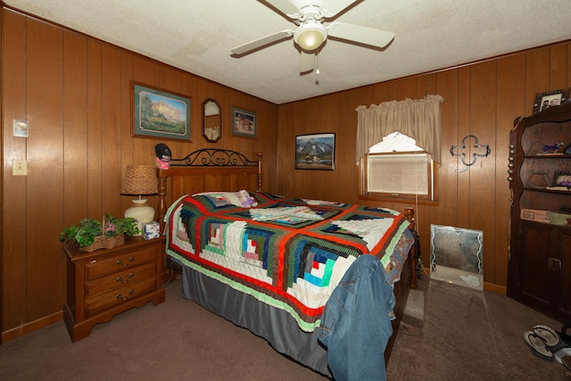 carpeted bedroom featuring a textured ceiling, ceiling fan, and wood walls