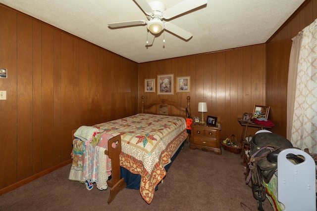 carpeted bedroom featuring ceiling fan and wooden walls