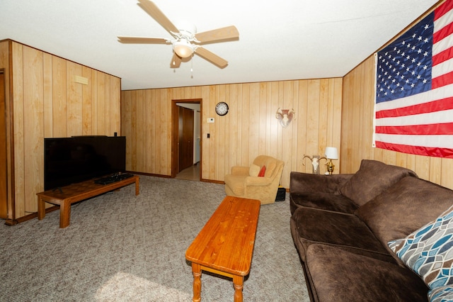 living room with ceiling fan, wood walls, and light colored carpet