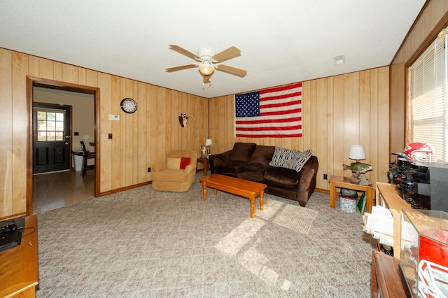 living room featuring light carpet, ceiling fan, and wooden walls