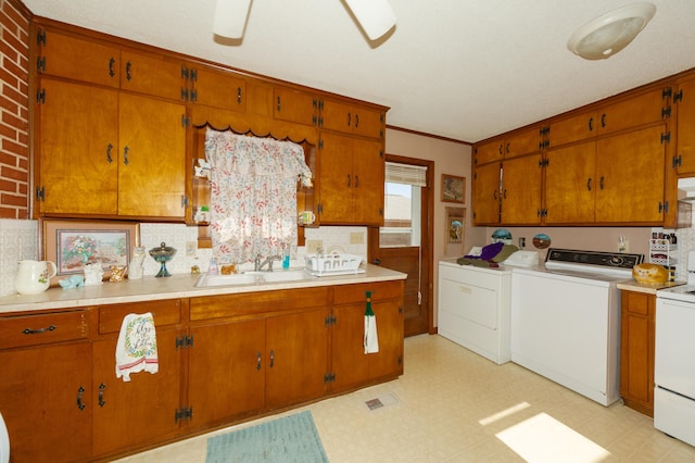 kitchen with washer and clothes dryer, sink, decorative backsplash, ornamental molding, and range