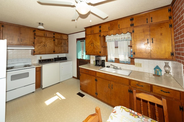 kitchen with ceiling fan, sink, a textured ceiling, white appliances, and washer and dryer