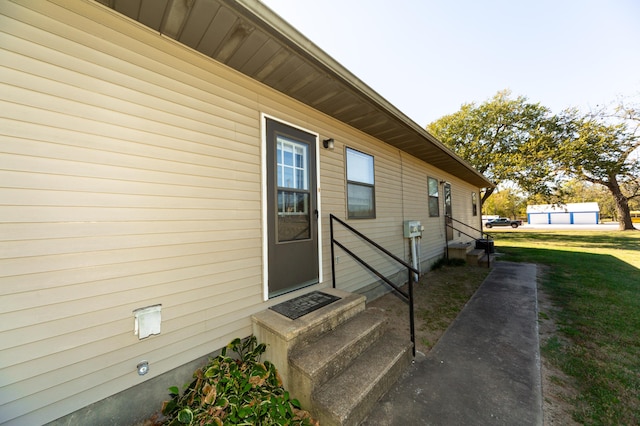 view of exterior entry with a yard