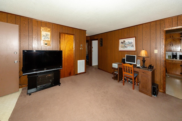 carpeted home office featuring wooden walls