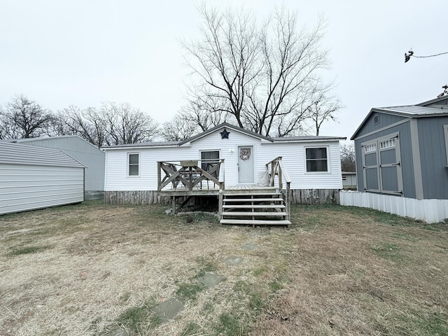 rear view of property with a shed and a wooden deck