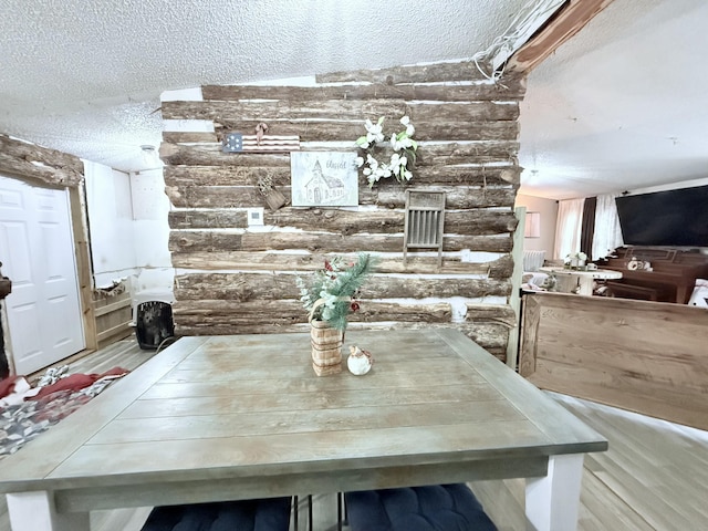 unfurnished dining area featuring log walls and a textured ceiling