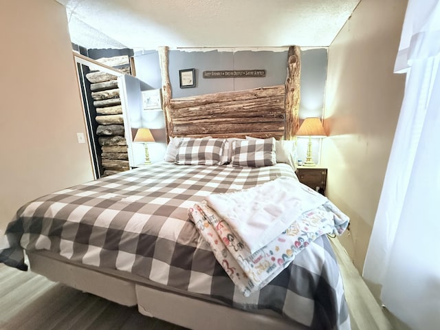 bedroom featuring wood-type flooring and a textured ceiling