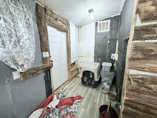 bathroom with hardwood / wood-style floors and a textured ceiling