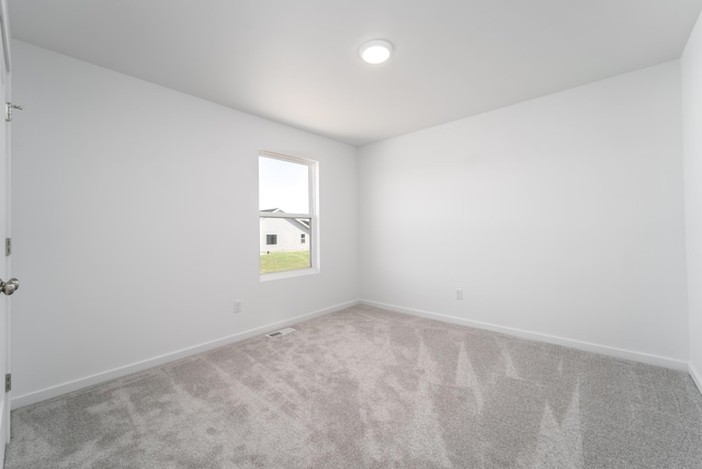 unfurnished room featuring light carpet