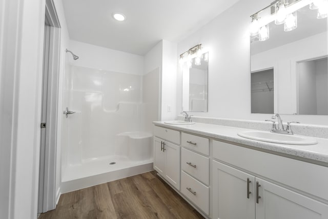 bathroom with vanity, wood-type flooring, and walk in shower