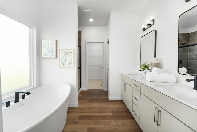 bathroom with separate shower and tub, vanity, and wood-type flooring