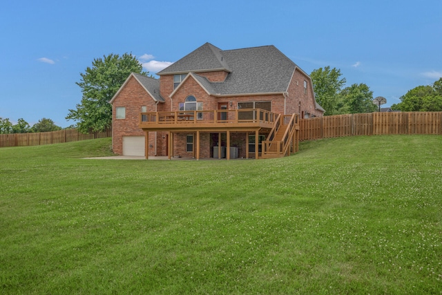 back of house featuring a lawn, a wooden deck, and a garage