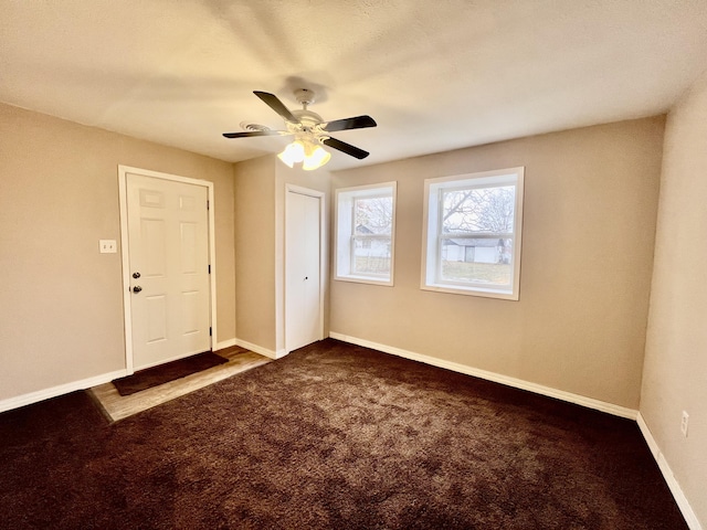 carpeted spare room featuring ceiling fan