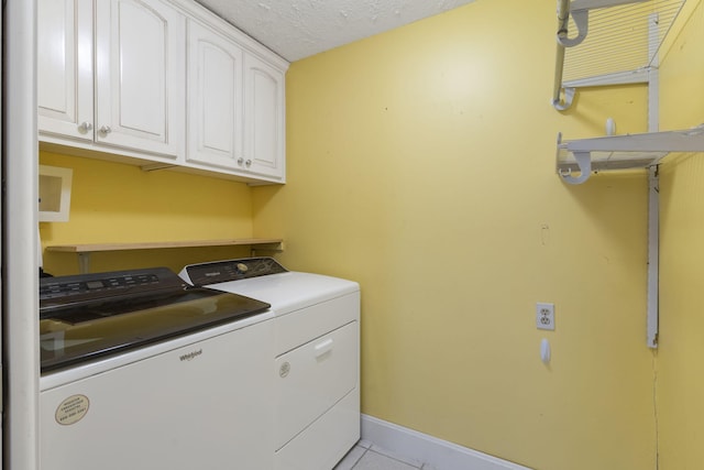 laundry area featuring cabinets, independent washer and dryer, a textured ceiling, and light tile patterned flooring