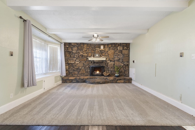 unfurnished living room featuring beamed ceiling, hardwood / wood-style flooring, a fireplace, and ceiling fan