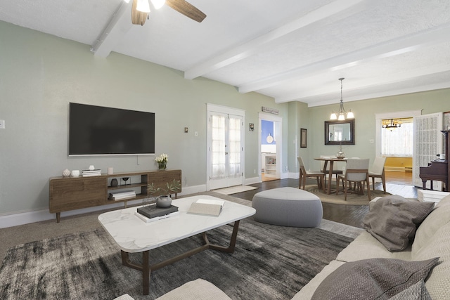 living room featuring beam ceiling, ceiling fan with notable chandelier, and dark hardwood / wood-style flooring