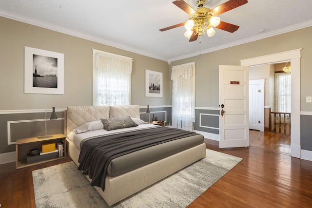 bedroom with ceiling fan, dark hardwood / wood-style flooring, and ornamental molding