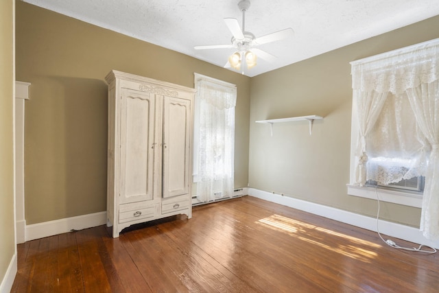 unfurnished bedroom featuring ceiling fan, dark hardwood / wood-style flooring, and a textured ceiling