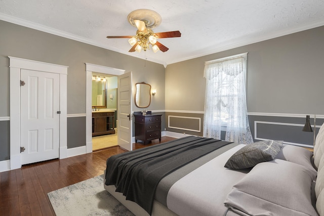 bedroom with dark wood-type flooring, ceiling fan, ornamental molding, a textured ceiling, and connected bathroom