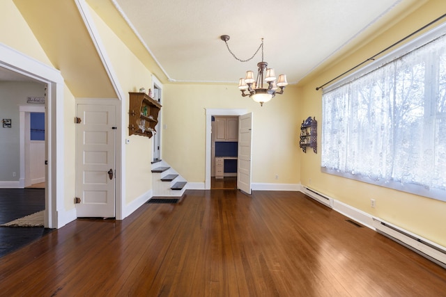 interior space with dark hardwood / wood-style floors, baseboard heating, and an inviting chandelier