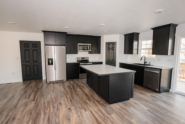 kitchen featuring sink, a kitchen island, stainless steel appliances, and wood-type flooring