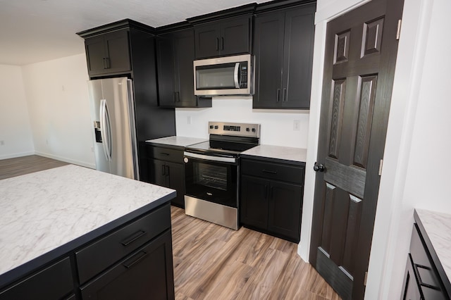 kitchen featuring appliances with stainless steel finishes and light hardwood / wood-style flooring