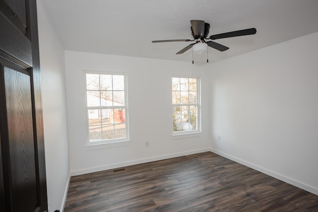 empty room with dark hardwood / wood-style flooring and ceiling fan