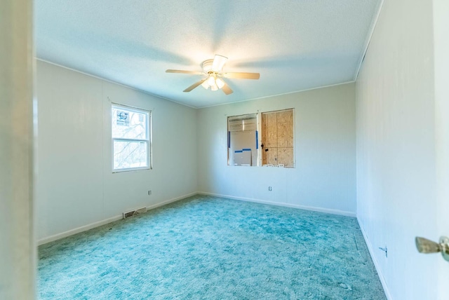 unfurnished room featuring carpet flooring, ceiling fan, ornamental molding, and a textured ceiling