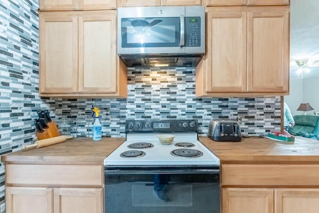 kitchen featuring electric range oven, light brown cabinetry, and tasteful backsplash