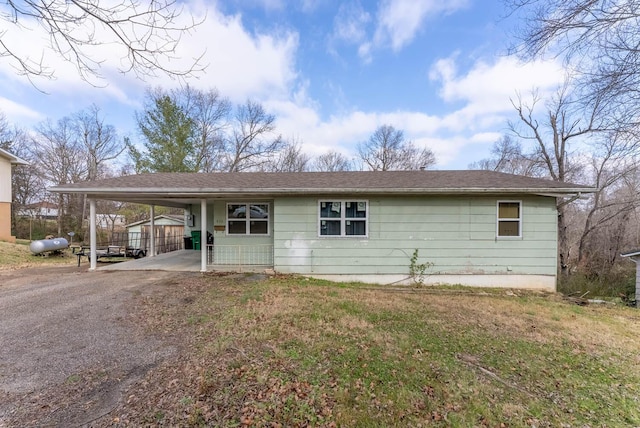 view of front of property featuring a front lawn and a carport