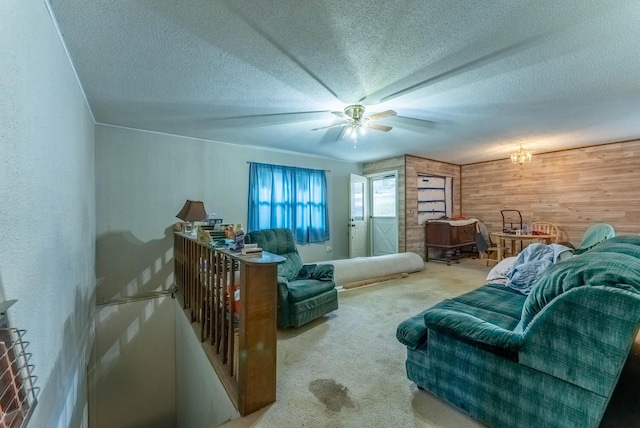 interior space with ceiling fan, wood walls, carpet floors, and a textured ceiling