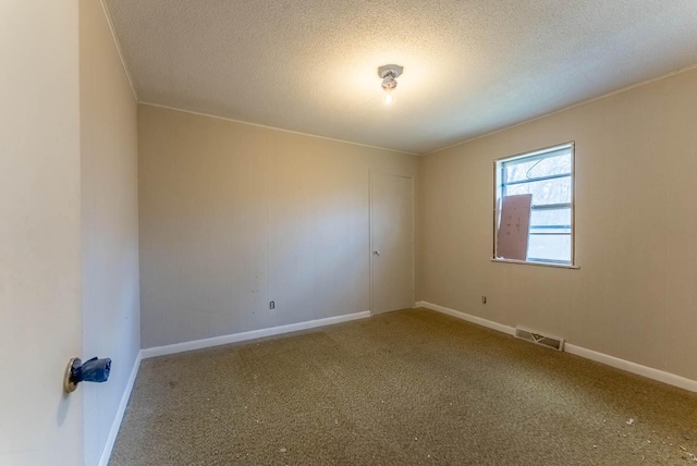 carpeted empty room featuring a textured ceiling