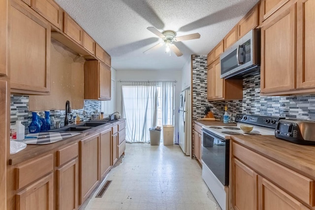 kitchen featuring decorative backsplash, white appliances, ceiling fan, and sink