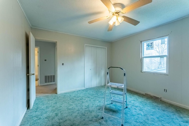 bedroom with ceiling fan, a closet, light carpet, and a textured ceiling