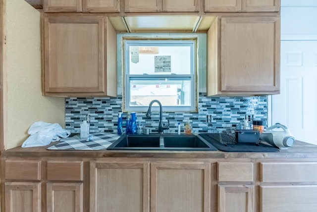 kitchen with light brown cabinetry, decorative backsplash, and sink