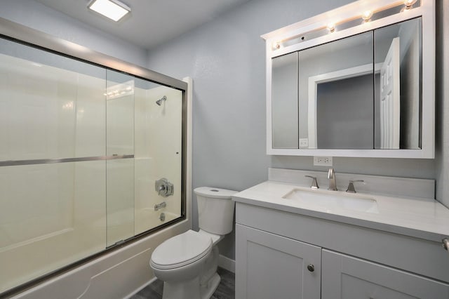 full bathroom featuring vanity, shower / bath combination with glass door, and toilet