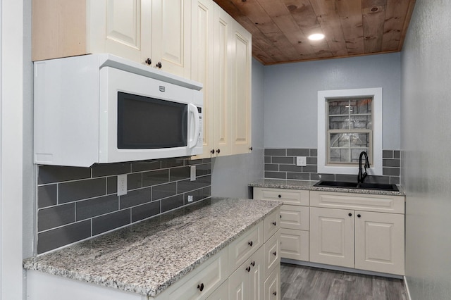 kitchen with tasteful backsplash, white cabinetry, sink, dark wood-type flooring, and wooden ceiling