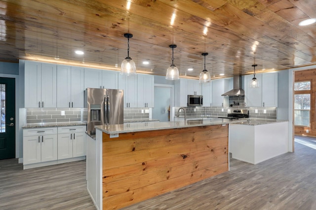 kitchen with hanging light fixtures, stainless steel appliances, white cabinets, and light stone countertops