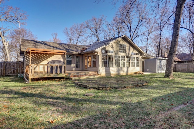 rear view of property featuring a wooden deck, a shed, and a lawn