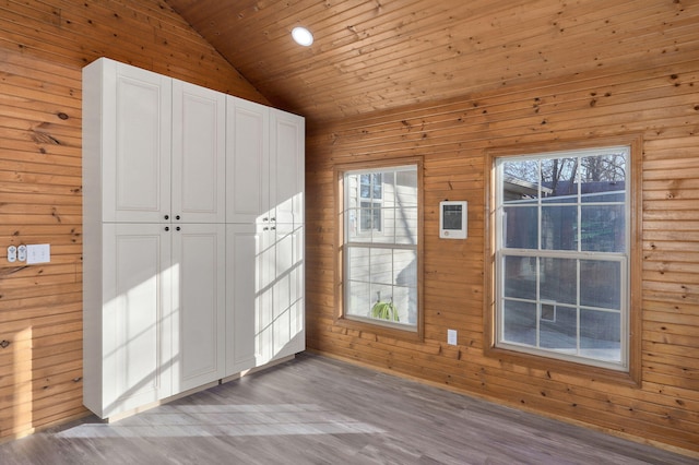 interior space with lofted ceiling, wood ceiling, light hardwood / wood-style flooring, and wooden walls