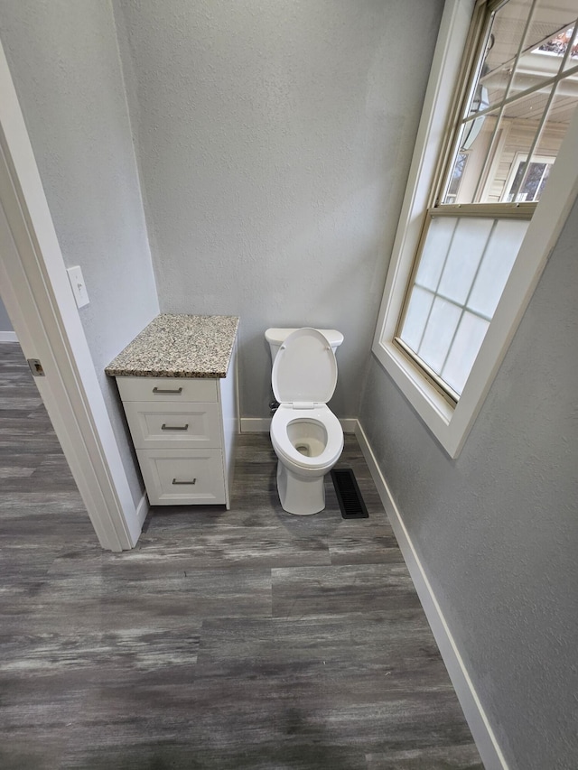 bathroom with toilet and hardwood / wood-style floors