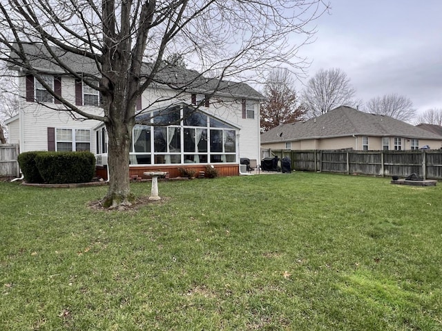 back of house with a sunroom and a lawn