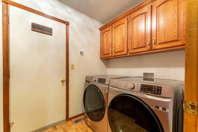 laundry room with cabinets, washing machine and dryer, and light parquet floors